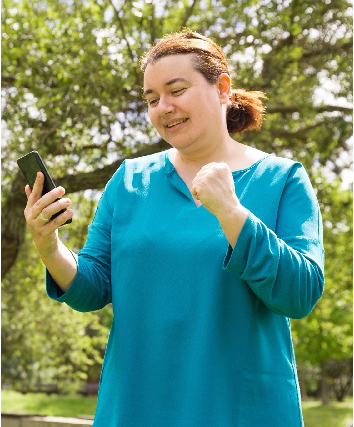 A happy woman looking at her mobile phone screen